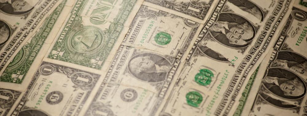 United States dollar bills lay over each other.